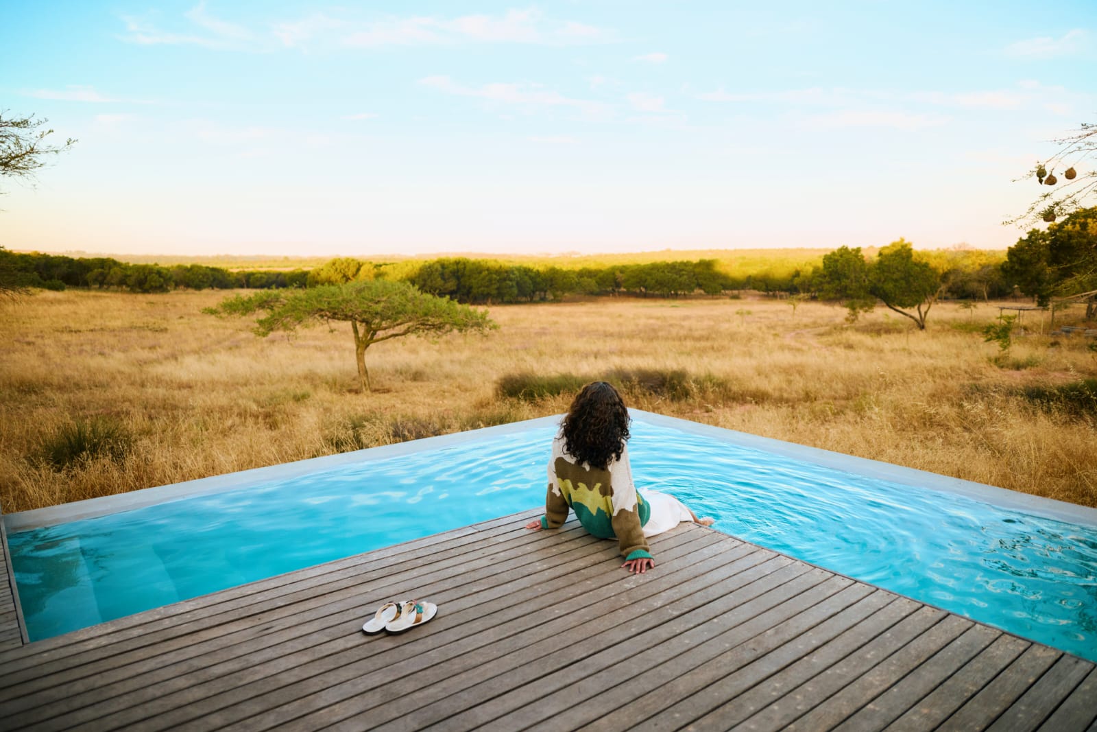 Jill sitting beside a pool overlooking the countryside